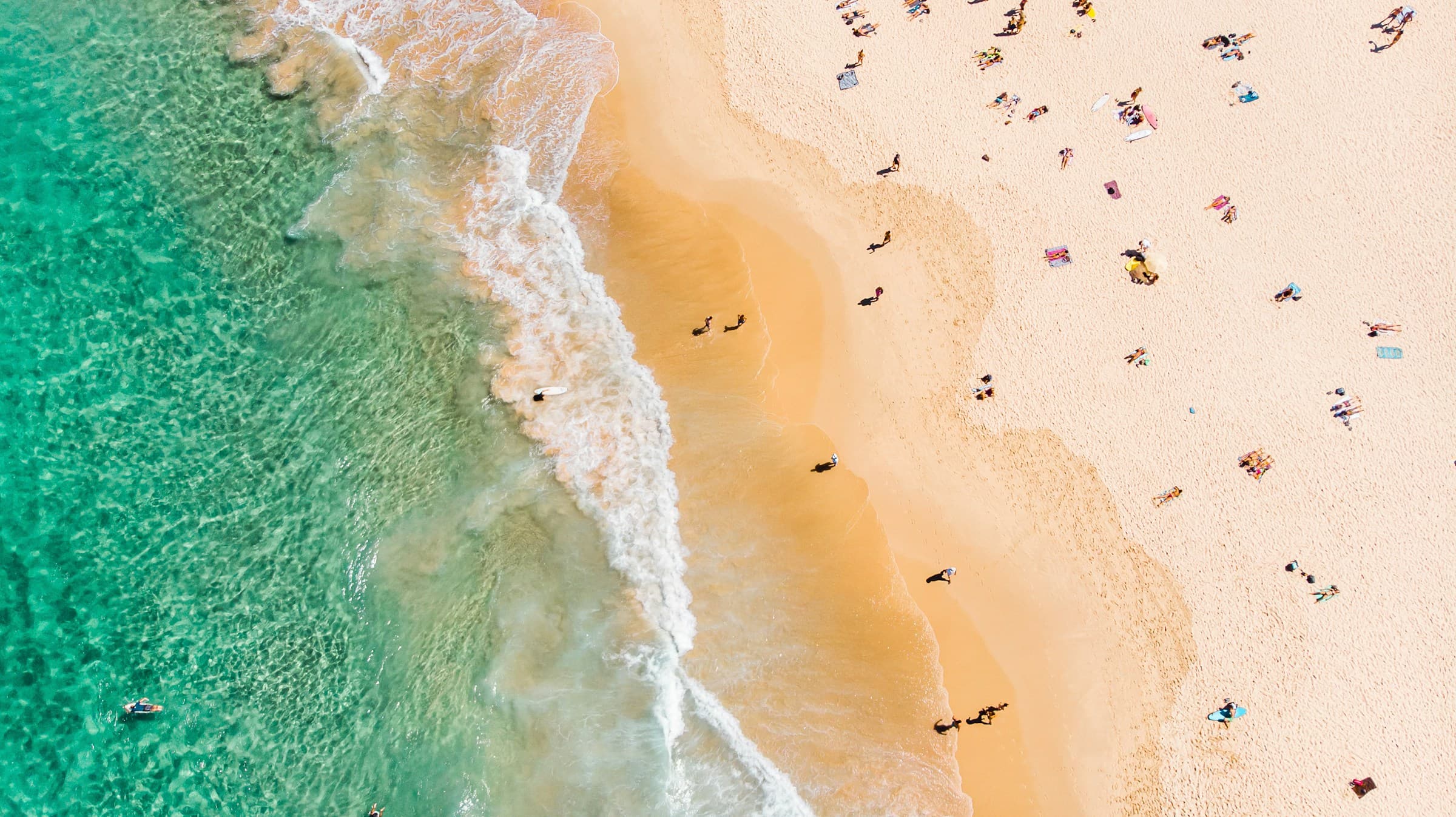 Sunbathers on a bright turquoise Atlantic beach on Florida's southeast coast.